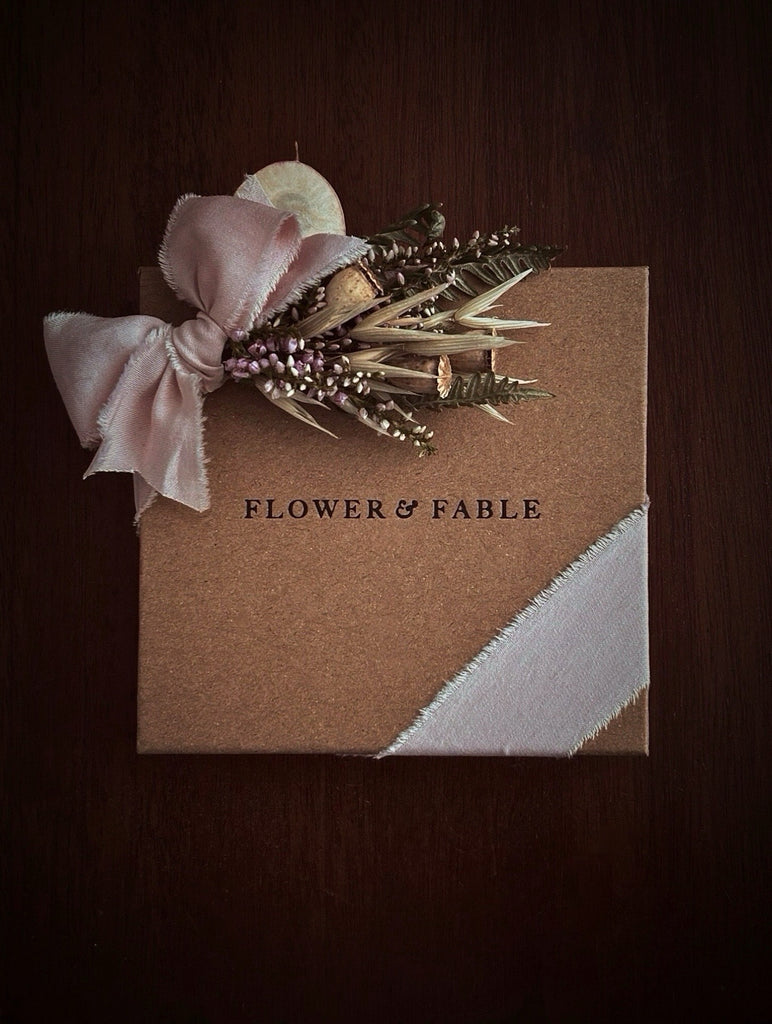 Gift box with floral arrangement and 'Flower & Fable' branding on a dark background