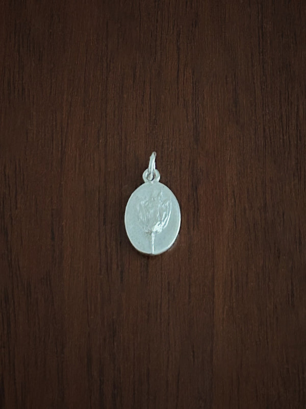 Bluebell Flower pendant in sterling Silver on a wooden surface