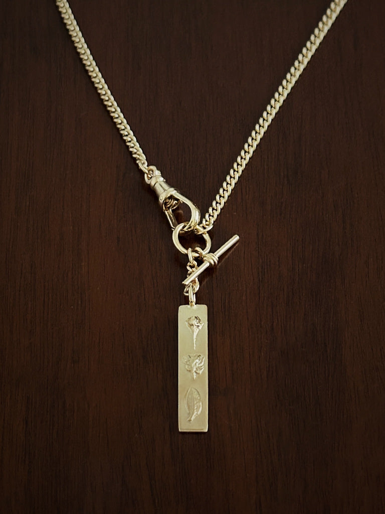 Gold curb watch chain necklace with a 'love' bar pendant