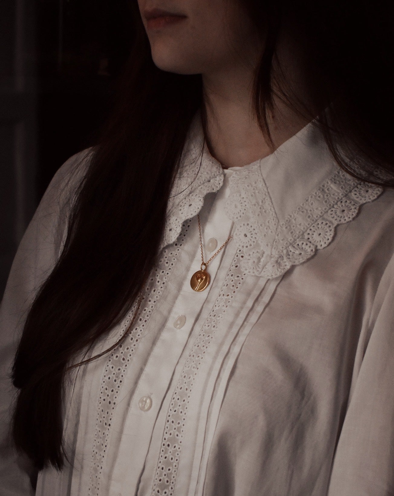 Gold Daisy Coin Charm modelled on a person to shown size reference