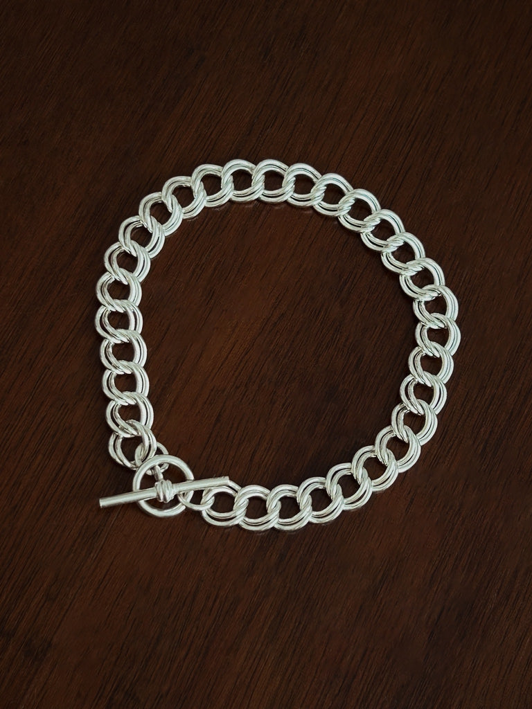 Silver chain bracelet on a wooden surface
