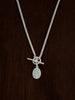 Sterling Silver Curb necklace with t-bar closure with a flower pendant on a dark wooden background