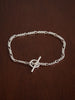 Silver bracelet with a t bar clasp on a wooden surface