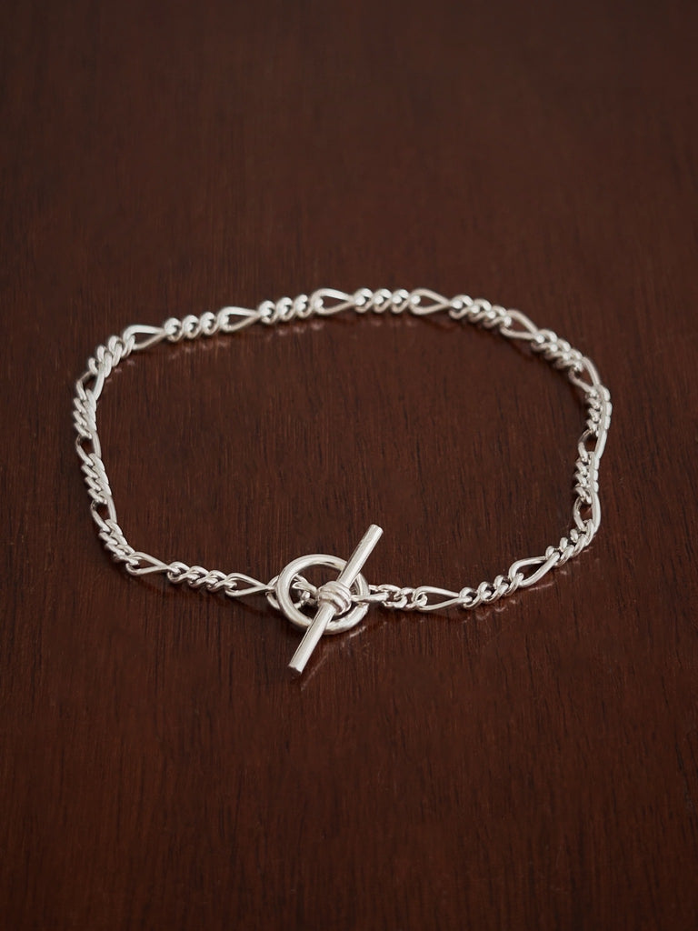 Silver bracelet with a t bar clasp on a wooden surface
