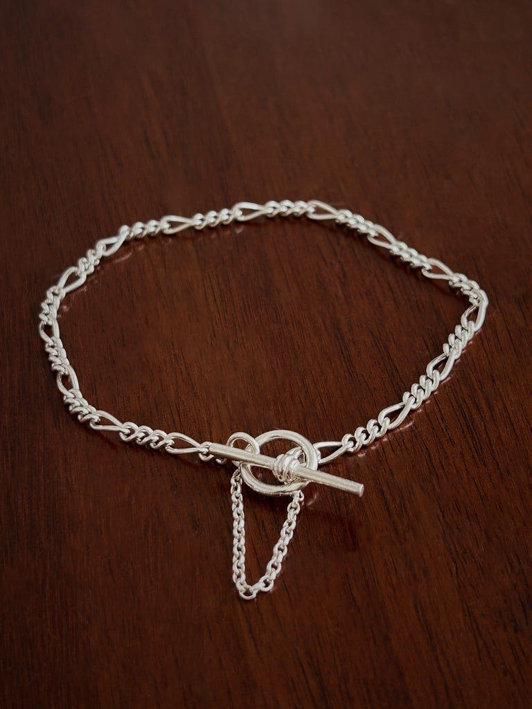 Silver figaro chain bracelet with a safety chain