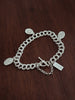 Silver chain bracelet with charms on a wooden surface