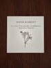 Card with illustration of Herb Robert and language of flowers meanings in Welsh on a wooden surface
