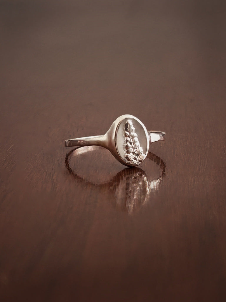 A delicate, comfortable signet ring cast from a real flower, designed to stack or wear on the little finger.