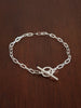 Sterling Silver paperclip chain bracelet with a b bar closure on a wooden surface