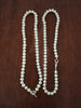 Pearl necklace showing both fastinings on a wooden surface
