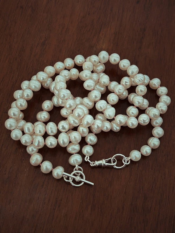 Pearl necklace on a dark wooden surface