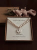 Pearl necklace with a silver snowdrop 
pendant in a 'Flower & Fable' box on a dark background