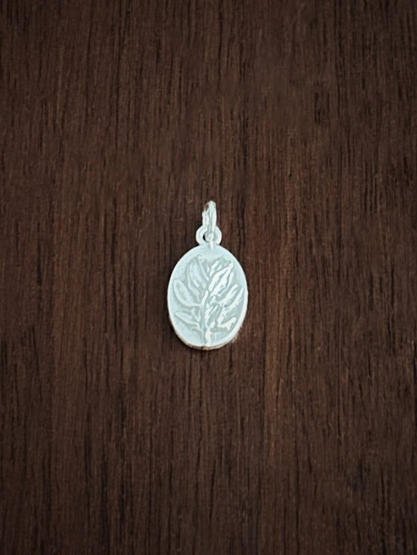 Silver thyme pendant for courage on a wooden surface
