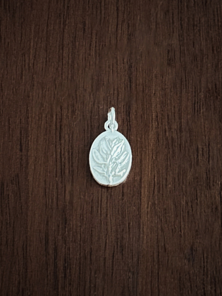 Silver thyme pendant for courage on a wooden surface