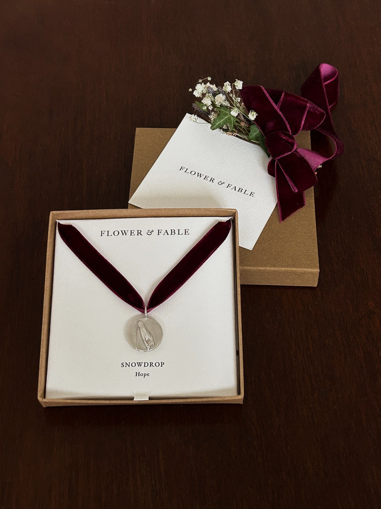 Sterling Silver Coin Pendant packaged with Flower & Fable branding on a dark background